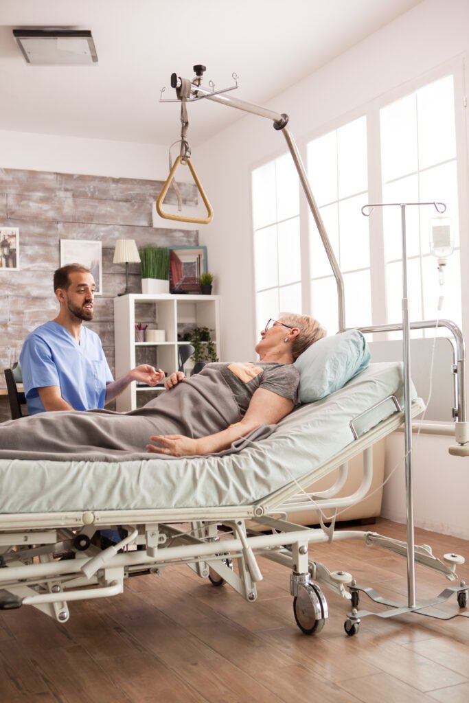 friendly male nurse talking with senior woman